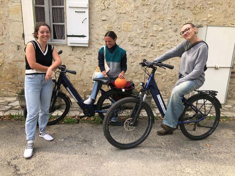 Trois bénévoles de L’été photographique de Lectoure posent avec des VTC Peugeot EC01 prêtés par « Au travail les vélos ! »