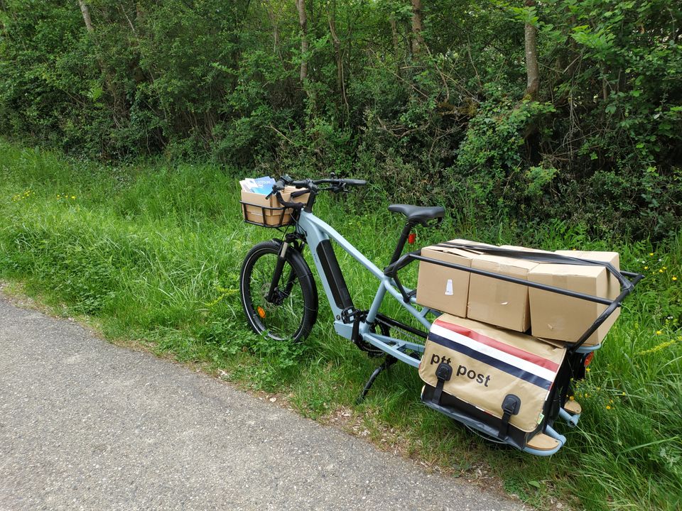 Vélo-cargo longtail Elops R500E transportant 60 kg de magazines dans des cartons et des sacoches