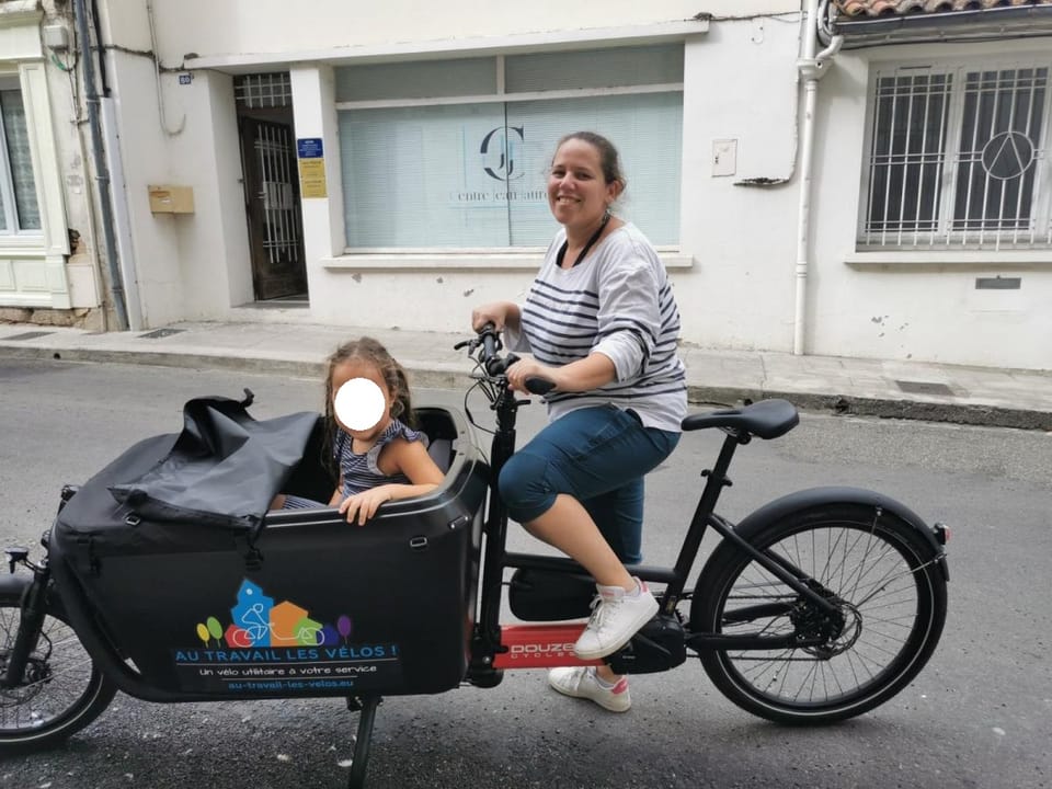 Nancy sur le vélo cargo avec sa fille 